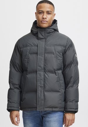 Puffer jacket in dark gray, featuring a high collar, front pockets, and quilted texture. Made of water-resistant material.