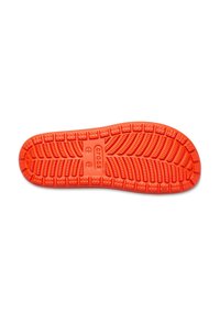 Semelle de chaussure en caoutchouc orange vif avec un motif de semelle texturé, comportant des rainures et des zones surélevées pour une meilleure adhérence et traction.