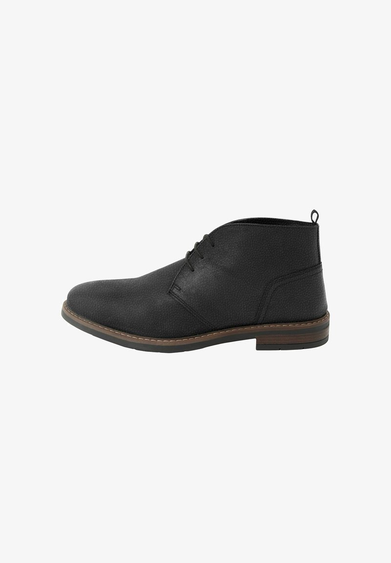 Stivale alla caviglia in pelle nera con lacci sul davanti, suola cucita in marrone e linguetta sul retro per una facile vestibilità.