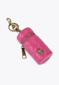 Różowy, pikowany skórzany pokrowiec na klucze w kształcie cylindra, z złotym zamkiem błyskawicznym, etykietą z logo i dekoracyjnym metalowym akcentem.