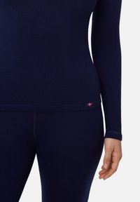 Marineblaues Langarm-Oberteil und passende Leggings aus glattem, dehnbarem Stoff. Verfügt über ein kleines Flaggenemblem am unteren Saum des Oberteils.