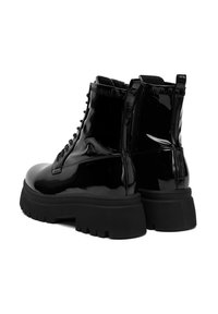 Czarne lakierowane botki za kostkę z grubą podeszwą, z sznurowanym przodem i zamkiem błyskawicznym z boku. Gładka faktura z wzmocnionymi detalami szwów.