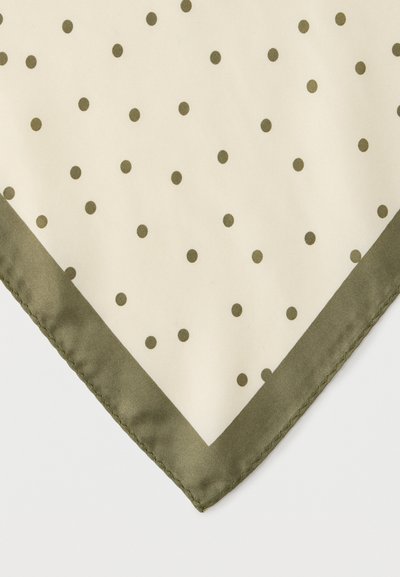 Γωνία από μπεζ ύφασμα με μικρές ελιά πράσινες πουά και περίγραμμα με ραμμένη ελιά πράσινη κλωστή.