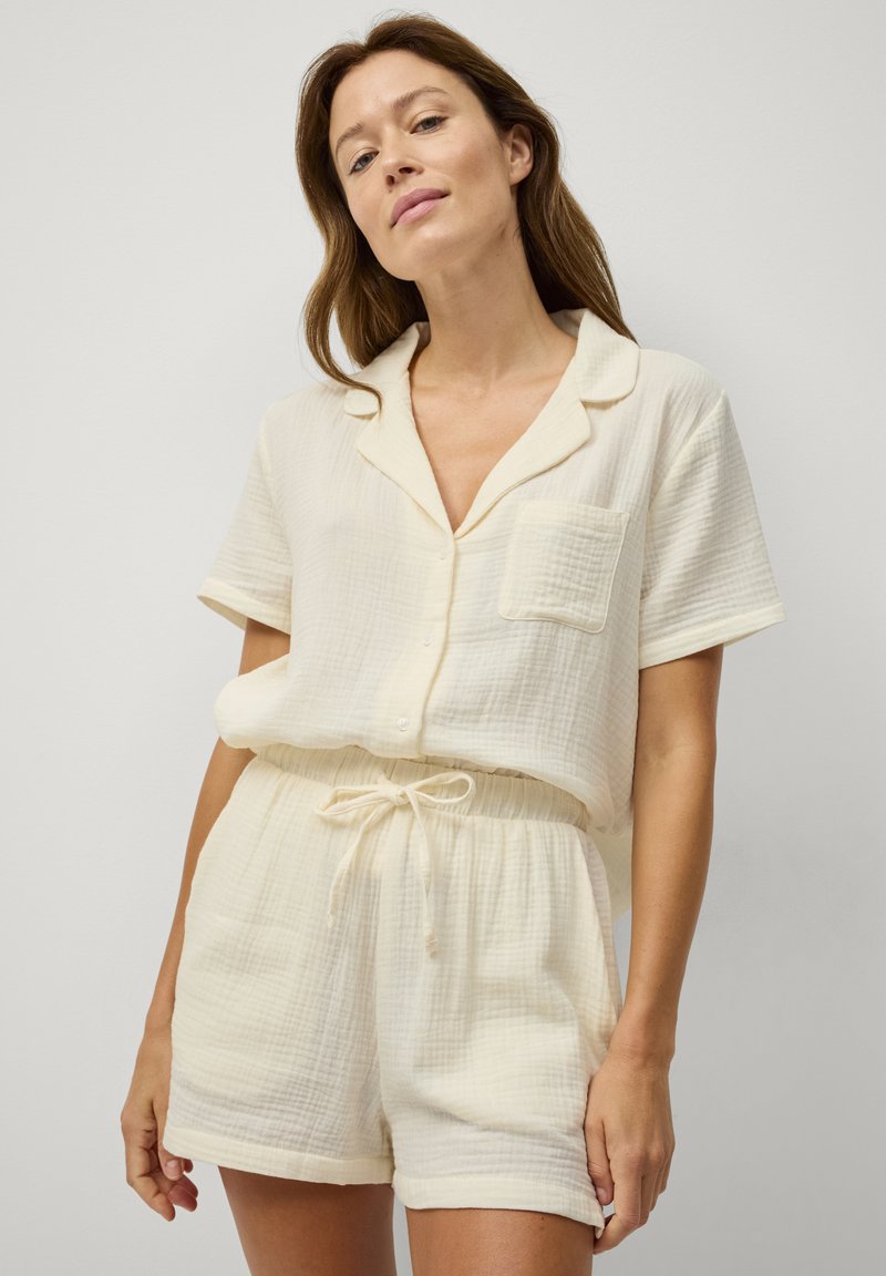 Letvægts, struktureret crepe kort pyjamassæt med en knap-op top, krave og korte ærmer. Elastisk talje med snor på shorts.