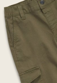 Olivgröna cargo shorts i slitstarkt material, med sidfickor, bältesöglor och knäppning. Slät textur med sömdetaljer.