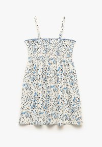 Vestido floral que presenta una tela blanca con patrones azules y negros, un cuerpo fruncido y tirantes delgados ajustables. Diseño ligero y veraniego.