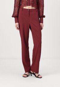 Pantalones de rayas burdeos con un corte entallado, confeccionados en tela suave, con cierre de cremallera, botón único y piernas rectas.