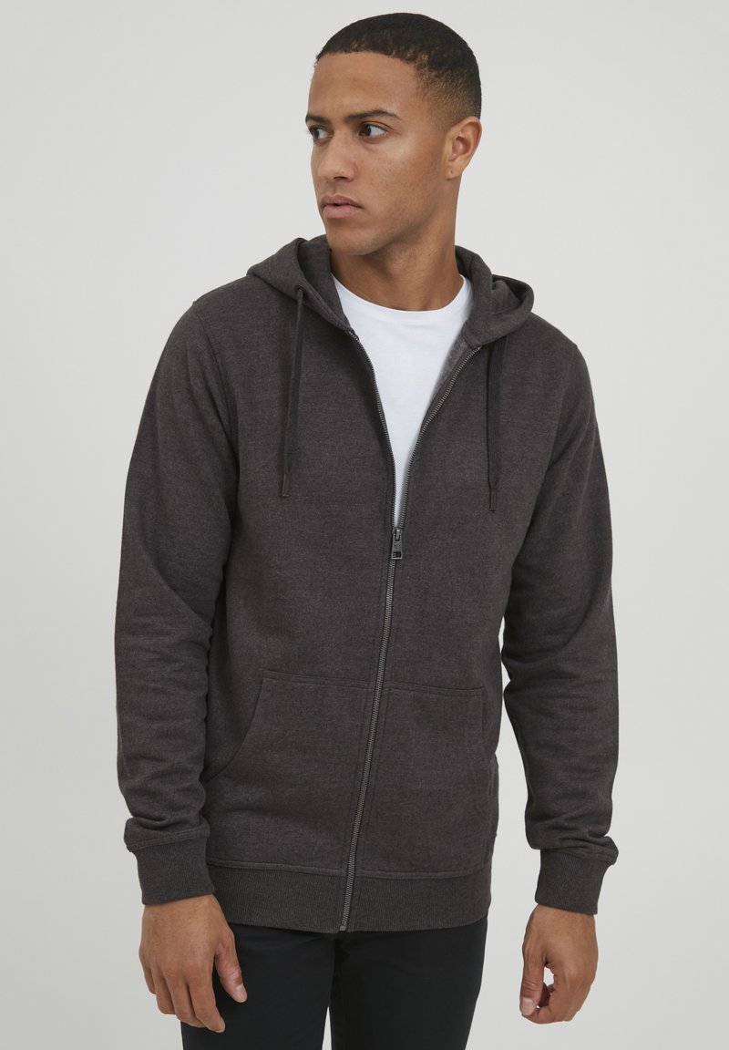 Dark grey zip-up hoodie made of soft fabric, featuring a drawstring hood, front pockets, and ribbed cuffs for a snug fit.