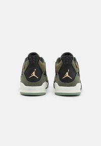 Zelené a černé tenisky s texturovaným designem, které mají na patě zlaté logo Air Jordan a bílé mezipodešve.