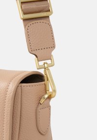 Tracolla di pelle beige con clip in metallo dorato. Superficie testurizzata, design piatto e accenti arrotondati. Dettagli di cucitura visibili.
