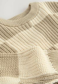 Beige und cremefarbener, grob gestrickter Pullover mit geripptem Rundhalsausschnitt, der breite horizontale Streifen und ein strukturiertes Strickmuster aufweist.