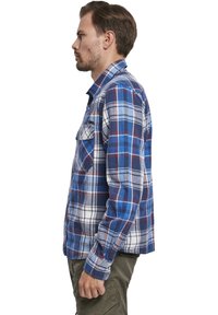 Geruite flanellen shirt in blauw, wit en rood. Knopsluiting, borstzak, lange mouwen met knoopmanchetten. Zachte stoftextuur.