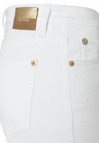 White denim jeans featuring a straight cut, gold-tone hardware, and a brown leather patch labeled "MAC" on the waistband.