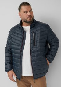 Dunkelblaue gepolsterte Jacke mit gestepptem Muster, hohem Kragen und kontrastierendem roten Reißverschluss. Verfügt über eine Brusttasche und Seitentaschen.