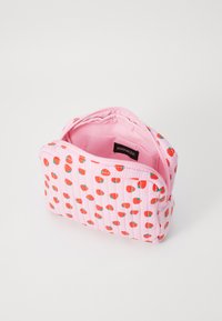 Trousse de maquillage rose avec un design rainuré et des motifs de fraises rouges. Fermeture éclair, doublure intérieure douce. Compacte et légère.