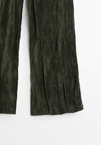 Pantalon large vert foncé en tissu doux et texturé présenté sur fond blanc.