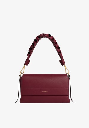 Sac à main en cuir bordeaux avec une finition texturée, anse supérieure tressée, fermoirs en or et logo "COCCINELLE" sur le rabat avant.