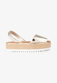 Sandalia plataforma slingback metálica dorada con media suela de yute trenzado y suela de goma blanca. Presenta una textura suave y un diseño de punta redonda.