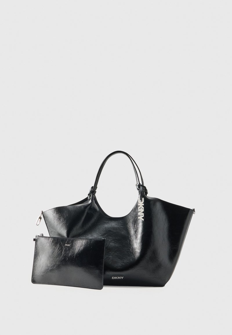 Sac cabas DKNY en cuir noir avec doubles anses, accompagné d’une pochette plate assortie à fermeture éclair, les deux avec des détails argentés de la marque.
