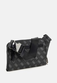 Bolso negro con un patrón geométrico, que cuenta con una superficie texturizada, cierre de cremallera y una correa ajustable con una hebilla metálica.