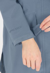 Grå vattentät jackärm med WPRO 10000-tryck, som har en kardborrestängning för justerbar passform och en slät tygkvalitet.