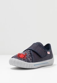 Navy canvas shoe with spider web design and red spider embroidery. Velcro strap, grey rubber sole with textured grip.