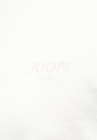 Λευκό βαμβακερό μπλουζάκι με διακριτικό, ανοιχτό ροζ γραφικό "JOOP! JEANS" τυπωμένο στην μπροστινή πλευρά. Ομαλή υφή με κλασική κοπή.
