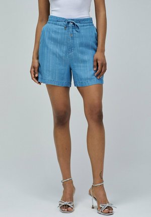 Shorts en denim bleu clair avec une taille à cordon, dotés d'accents de couture verticale et d'une coupe décontractée, se terminant au-dessus du genou.
