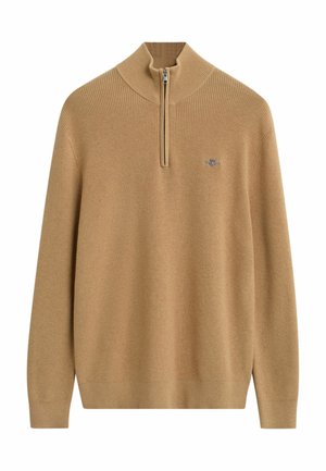 Kamelbrun ribbet striktrøje med kvart-lynlås krave og lille broderet logo på venstre bryst, lange ærmer og fitted manchetter.