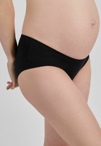 Černé těhotenské spodenky z hladkého a pružného materiálu. Mají nízký střih, bezešvé okraje a pohodlné nošení kolem břicha.