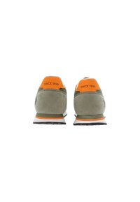 Green suede sneakers with orange heel accents, padded collar, and white rubber sole. Features "Since 1890" text on the back.