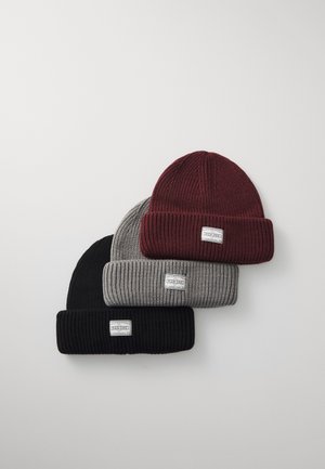 Tres gorros de canalé en burdeos, gris y negro. Cada uno cuenta con un dobladillo y una pequeña etiqueta de marca en la parte frontal. Un gorro cálido y elegante.