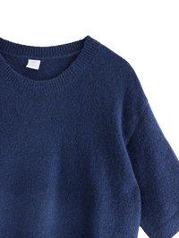 Ciemnoniebieski sweter z dzianiny z okrągłym dekoltem, ściągaczami przy rękawach i fakturowaną powierzchnią. Miękki, przytulny materiał, krótkie rękawy.