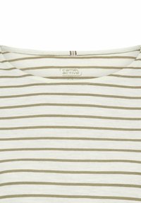 Stribet T-shirt i creme med lysebrune vandrette striber, der har en rund halsudskæring og blød tekstur. Brandinglabel synlig indvendigt.