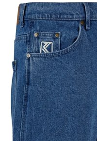 Traperice u srednje plavoj boji s teksturiranim završetkom, s logom na stražnjem džepu i metalnim detaljima.