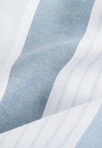 Tekstilna tkanina z izmeničnimi svetlo modrimi in belimi črtami, ki ima teksturiran vzorec tkanja. Mehka, gladka površina z izrazitimi linijami.