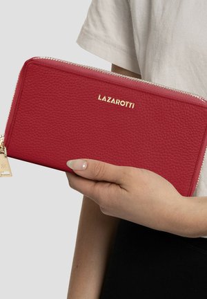 Red textured leather wallet with gold logo "LAZAROTTI," zipper closure, and metal charm accent. Held in a hand against a neutral background.