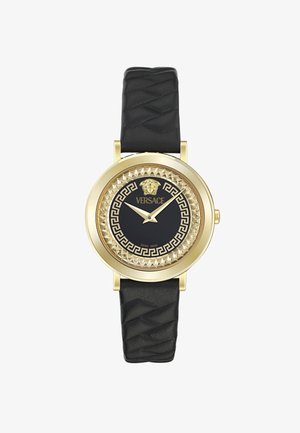 Orologio in tonalità oro con un cinturino in pelle nera texturizzata. Il quadrante nero presenta un logo di leone, un motivo a chiave greca e una lunetta decorativa.