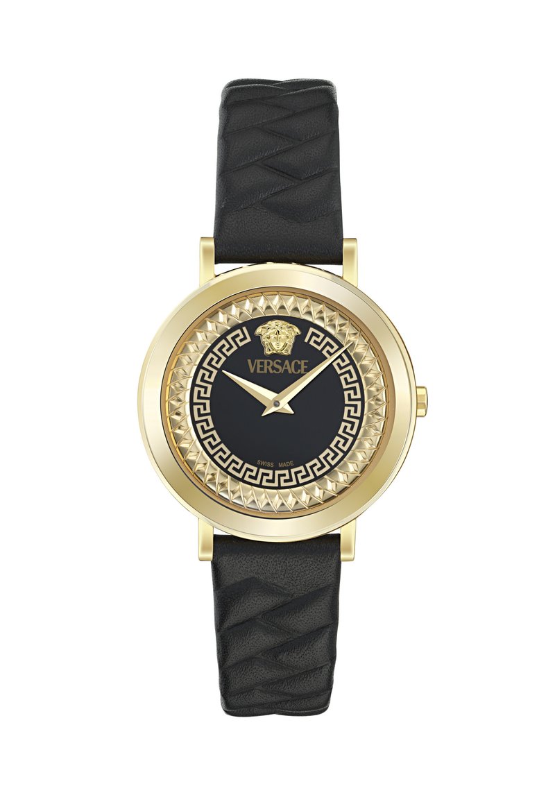 Gold-tone watch with a textured black leather strap. Black face features a lion logo, Greek key pattern, and decorative bezel.