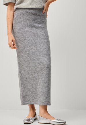 Gray knit maxi skirt with a high waist and soft texture. Paired with silver flat shoes, set against a neutral background.