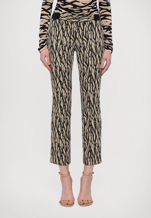 Trousers featuring a bold black and beige zigzag pattern, made from a smooth fabric, with a fitted waist and cropped hem.