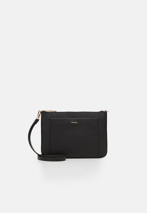 Černá psaníčko na zápěstí s přední kapsou, zlatým zipem a odnímatelným popruhem na jednobarevném bílém pozadí.