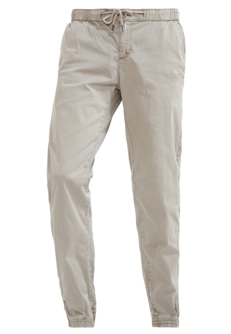 Ljust beige, bomullsblandade byxor med elastisk midja, dragskoöppning och smalnande bendesign. Slät textur, inga framträdande mönster.