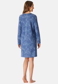 Langärmliges, knielanges Kleid aus weichem blauen Stoff mit weißen Blumenmustern, einfachem Rundhalsauschnitt und legerer Passform.