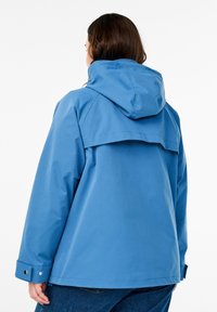 Giacca impermeabile blu con cappuccio, dotata di una pattina posteriore, polsini con bottoni e texture liscia, adatta per l'abbigliamento outdoor.