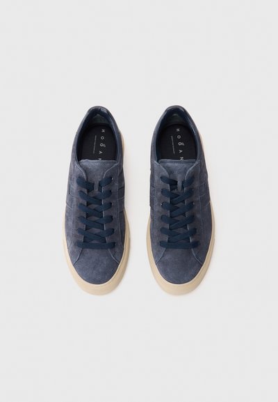 Pair of blue suede sneakers with dark blue laces and white rubber soles, viewed from above on a white background.