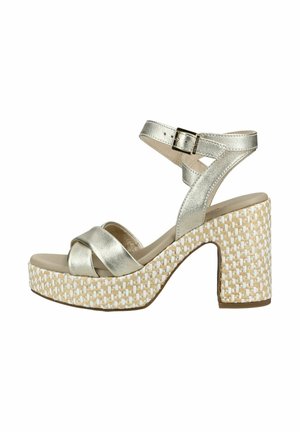 Sølvfarvet metallisk sandal med stropper, flettet platformblokhæl og justerbar ankelspænde.