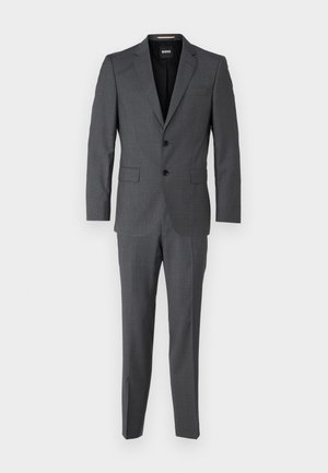 Pilkas dviejų dalių kostiumas, pagamintas iš tekstūruoto audinio, su vieno mygtuko švarku ir tiesiomis kelnėmis.