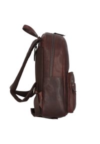 Sac à dos en cuir marron avec une finition texturée. Il dispose d'une fermeture zippée et d'une poche latérale avec un rabat. Bretelles ajustables pour le transport.