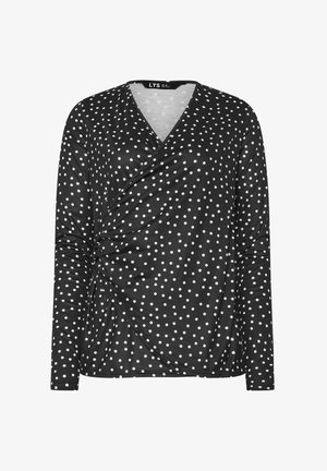 Czarna bluzka z długim rękawem w białe kropki, z przekładanym fasonem i marszczonym wykończeniem po jednej stronie. Miękki, elastyczny materiał.